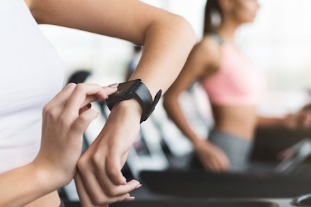 Sportswoman looking at smartwatch at gym.