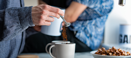 Person making coffee on kitchen counter.
