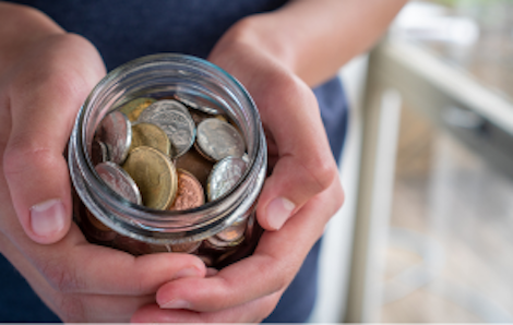 Image of a woman holding a jar full of coins