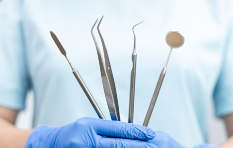Image of a dentist holding dental tools