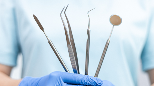 Image of a dentist holding dental tools
