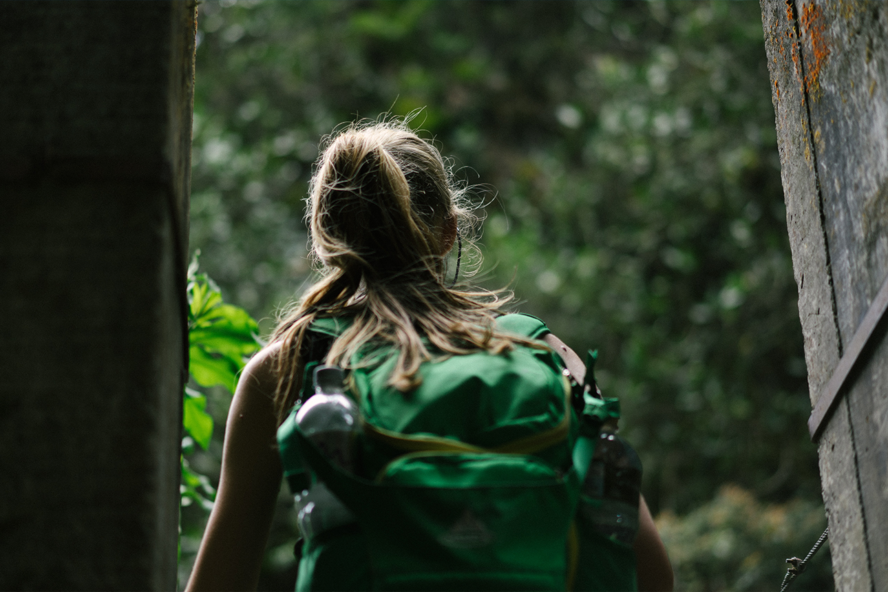 Woman with backpack getting out the door.