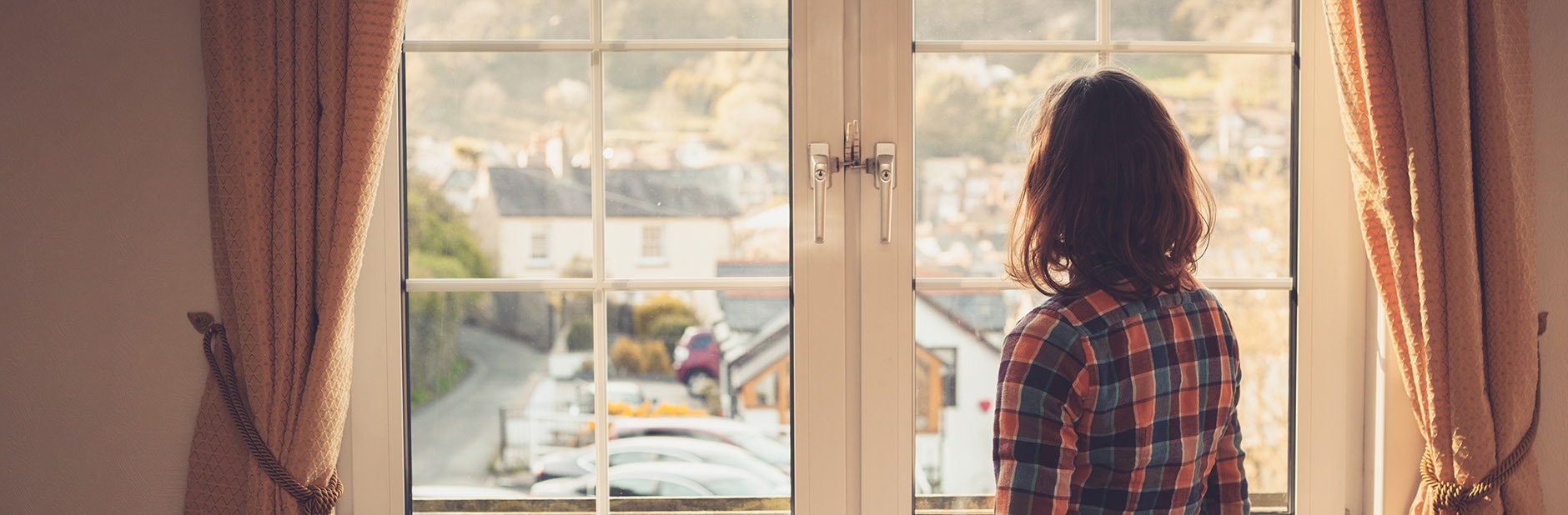 Young woman looking at windows during flat viewing