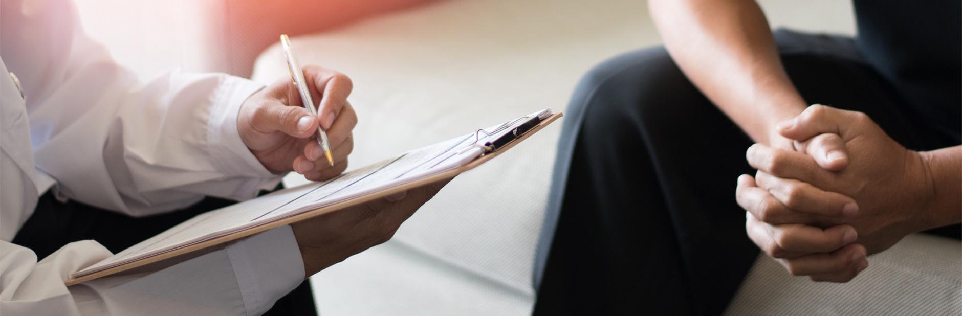 Therapist taking notes from patient.