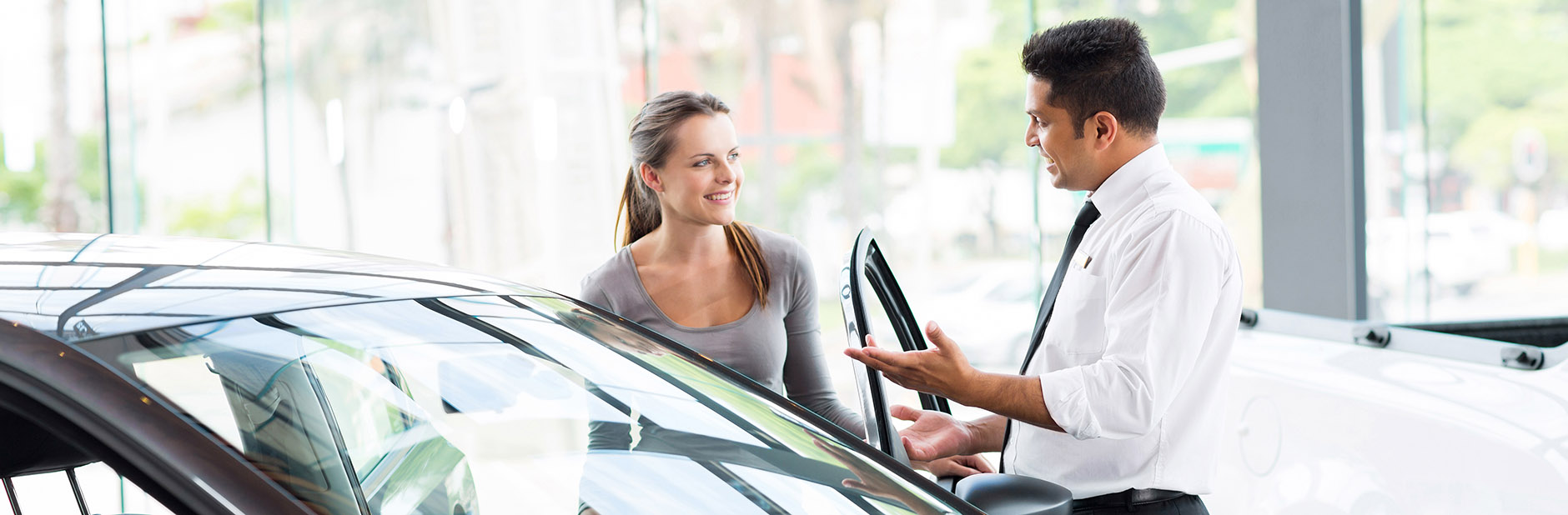 Woman speaking to car salesman.