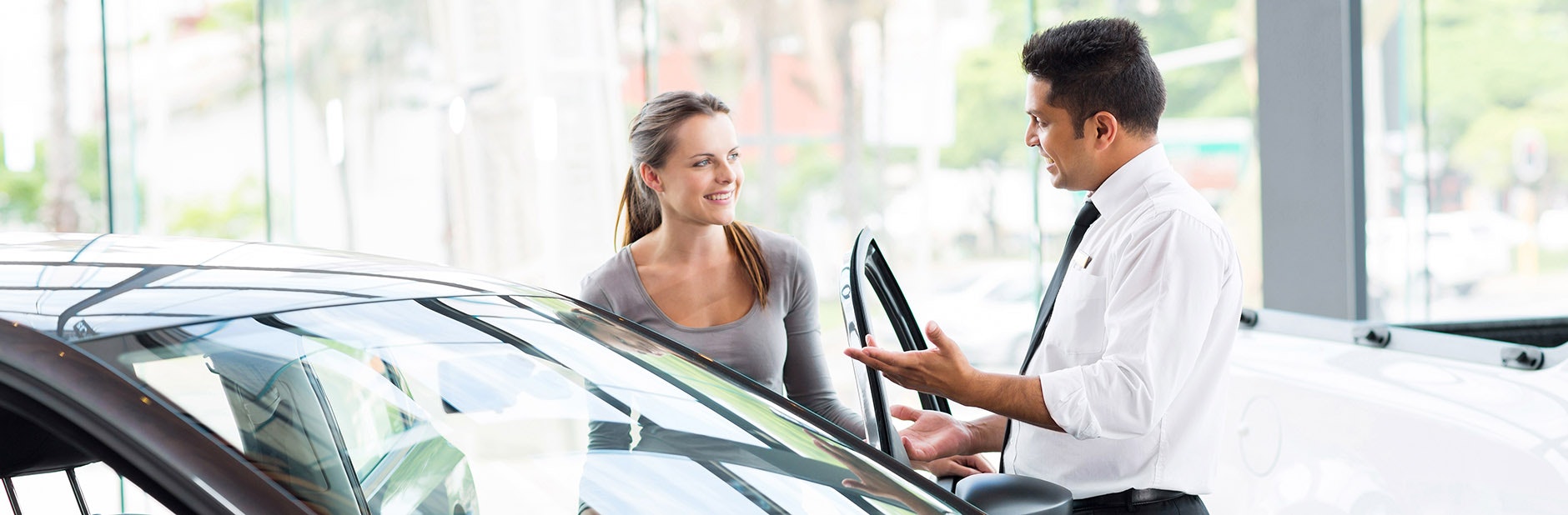 Woman speaking to car salesman.