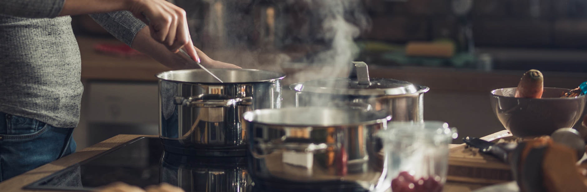 Woman cooking on stovetop.