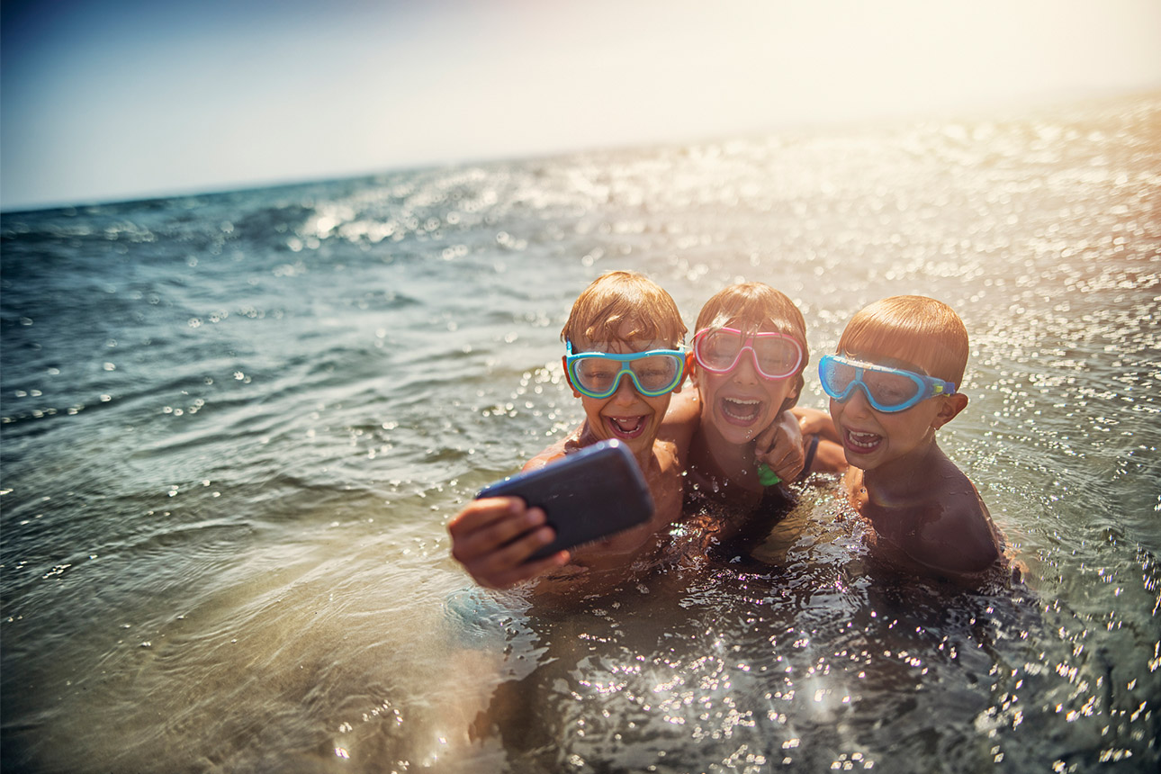 Kids taking selfies in the ocean.