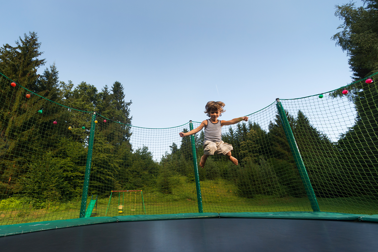 Kid jumping on trampoline.
