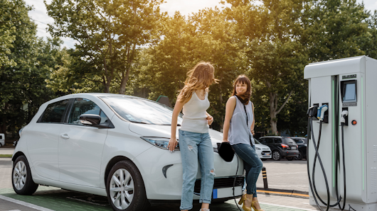 Women charging electric car.