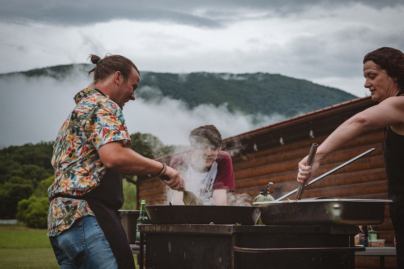 Photograph of a family barbecuing outdoors.