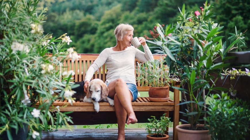 Image of a woman drinking tea next to her dog