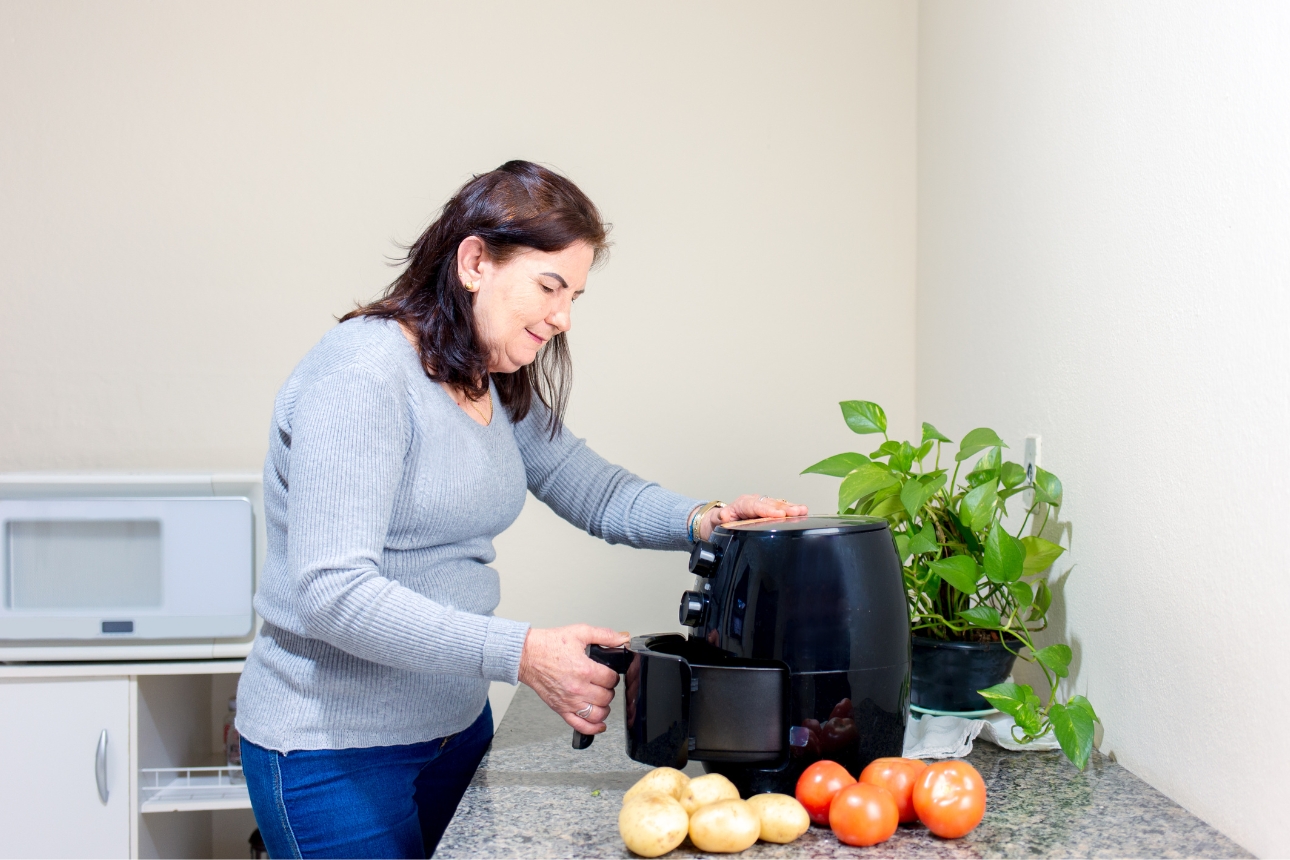 Image of a woman using an air fryer