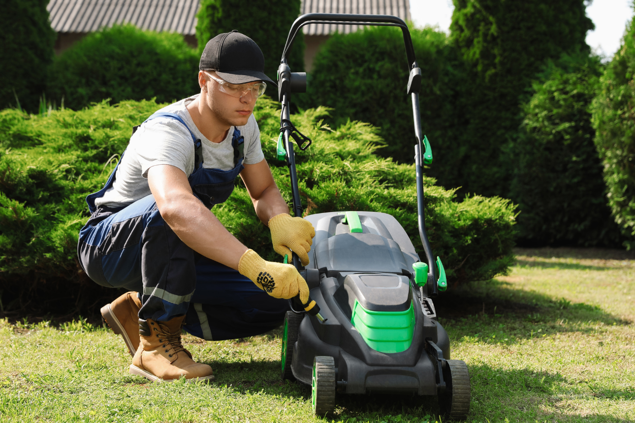 Man doing maintenance on a lawn mower.