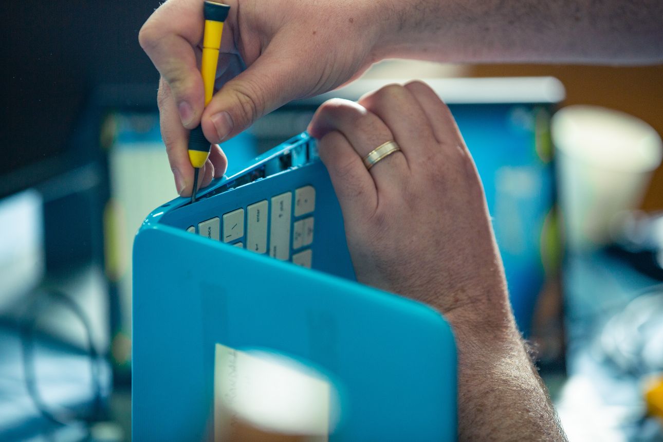 Image of a man fixing a laptop