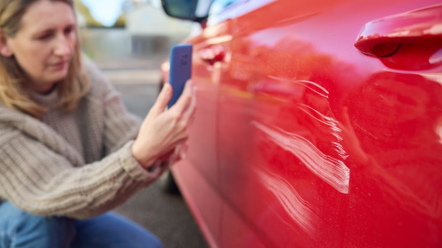 Consumer nz website promo image a woman takes a photo of damage caused to a car for insurance purposes width