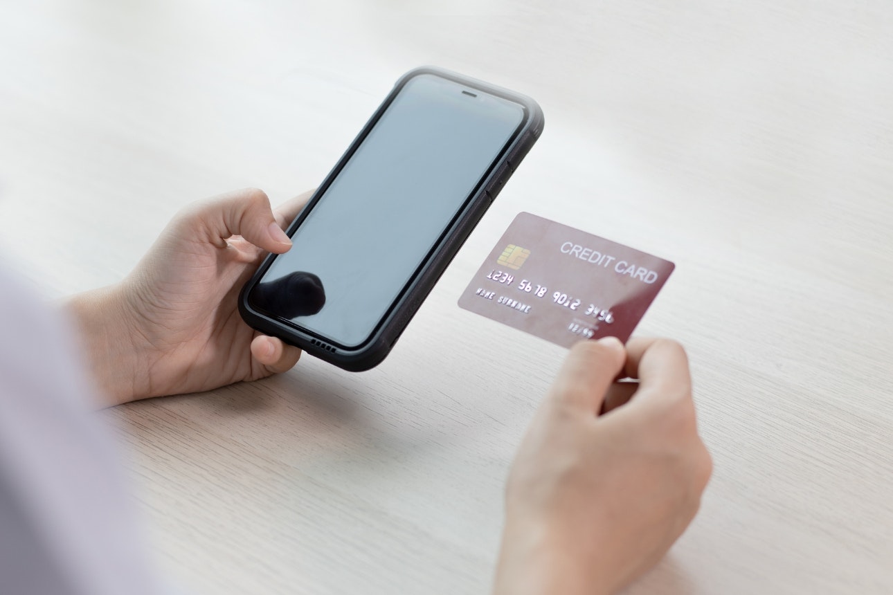 Person putting card details into phone.