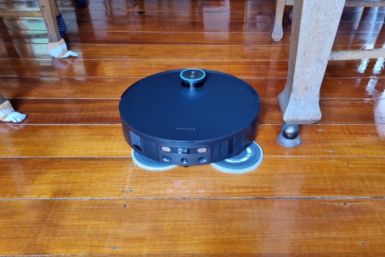 Robot vacuum on wooden floor.
