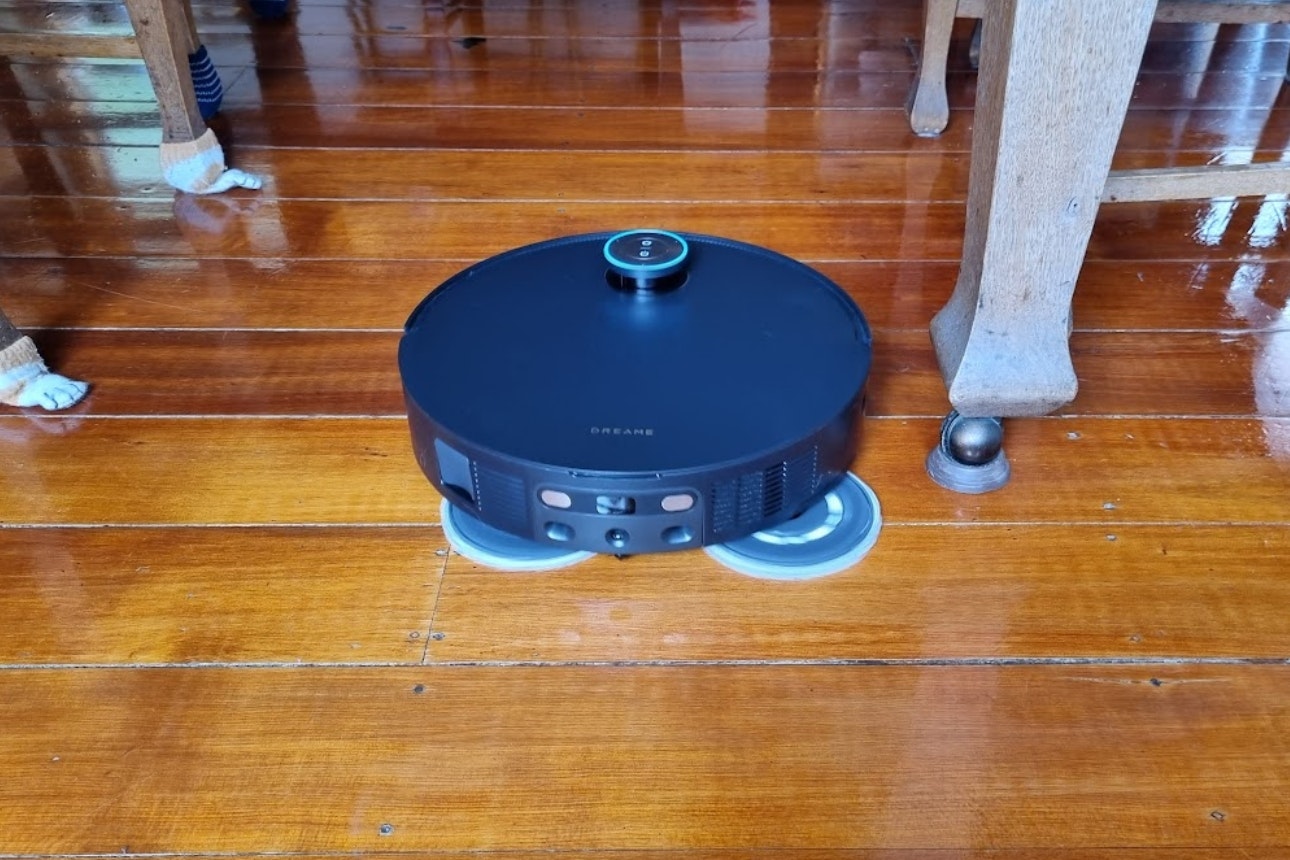 Robot vacuum on wooden floor.
