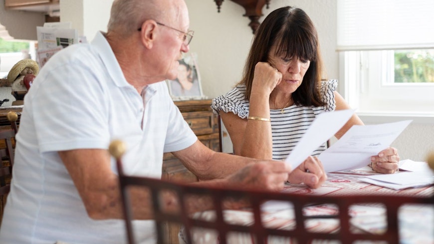 Consumer nz website promo image senior couple sitting at home table managing insurance width