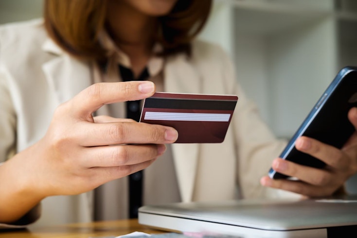 Woman holding a card and phone