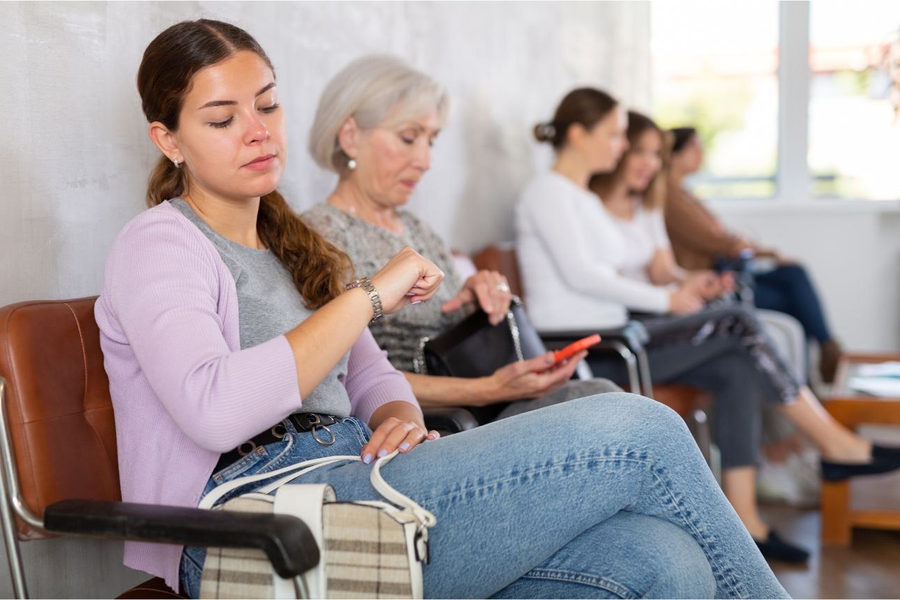a young woman waits in a doctors waiting room