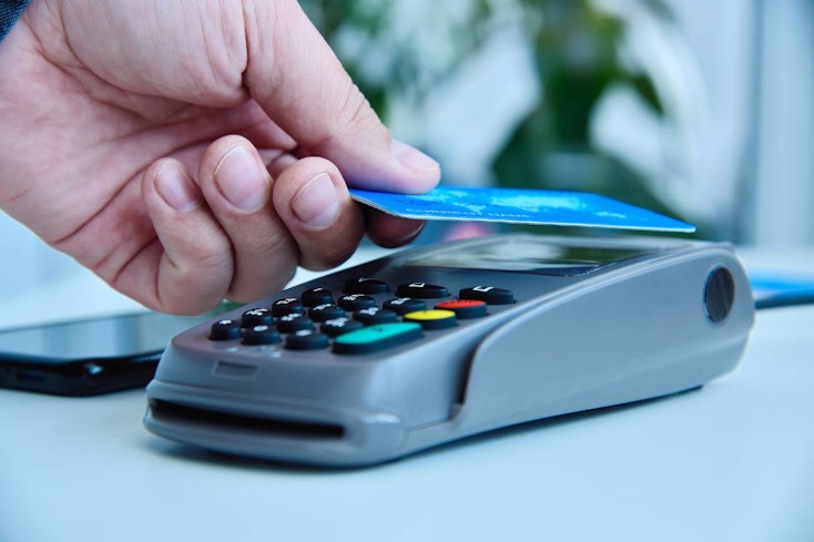 Image of woman tapping her card on an eftpos machine