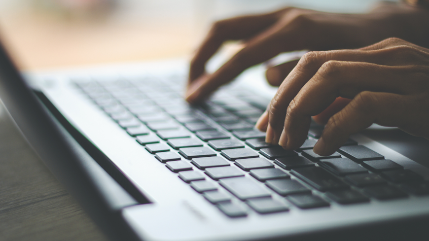 Image of a woman typing on a laptop