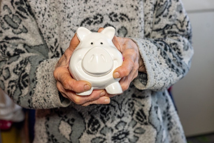 Image of a woman holding a white piggy bank