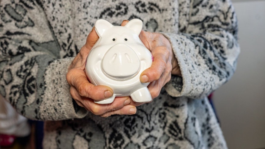 Image of a woman holding a white piggy bank