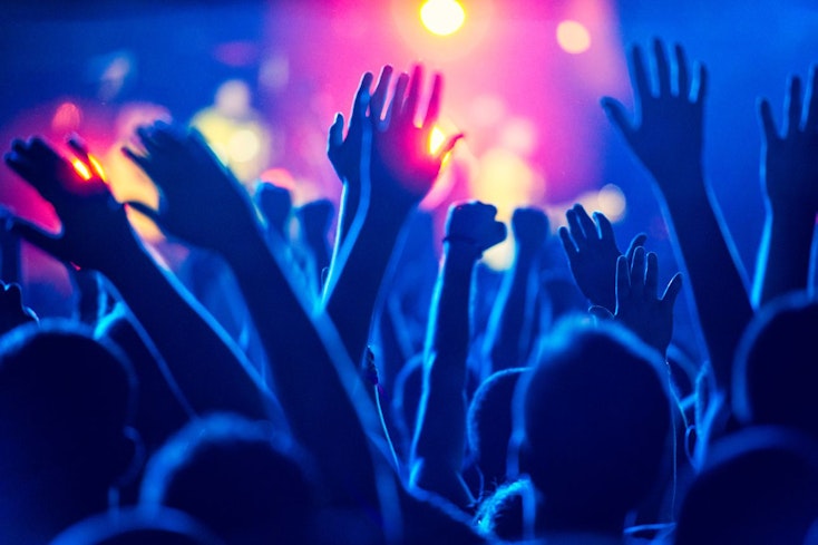 Image of hands up at a concert