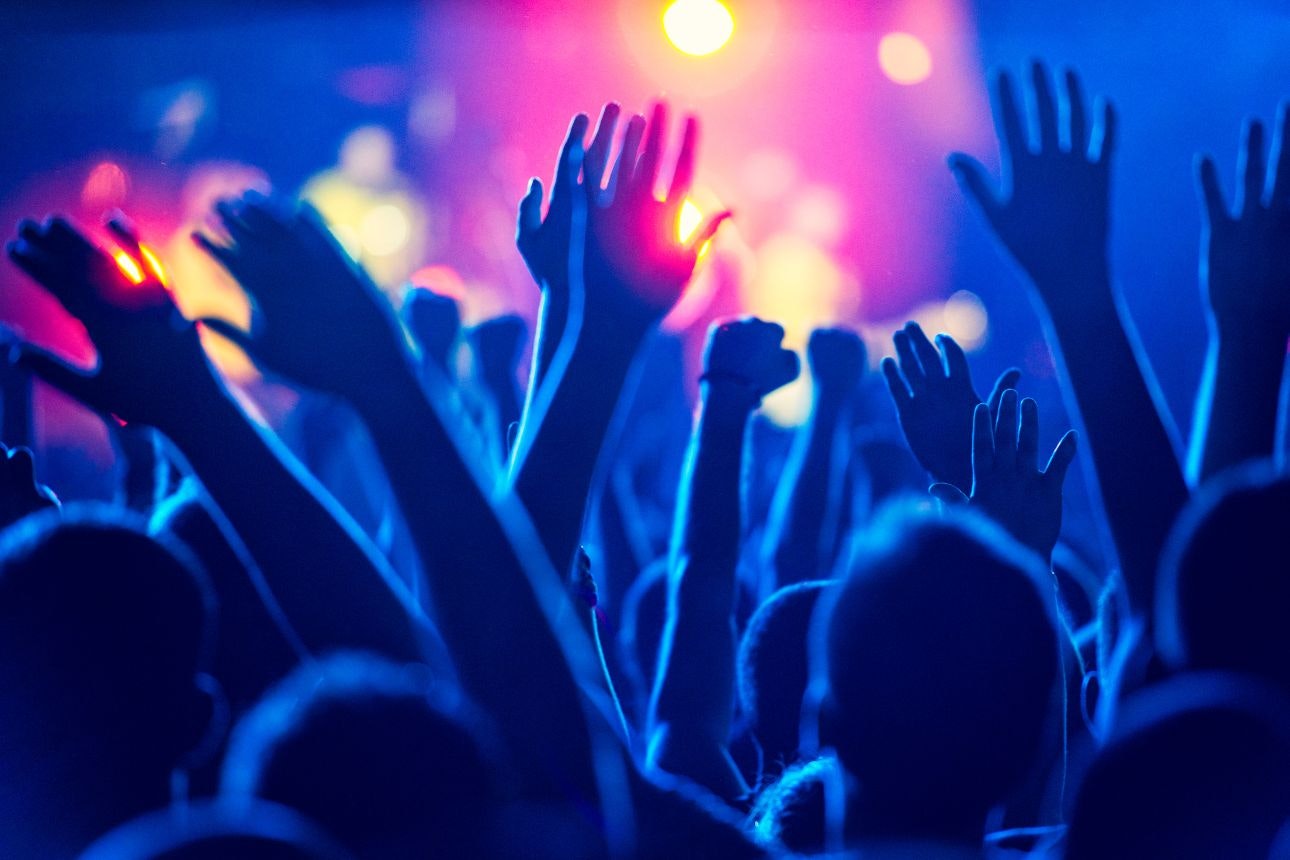 Image of hands up at a concert