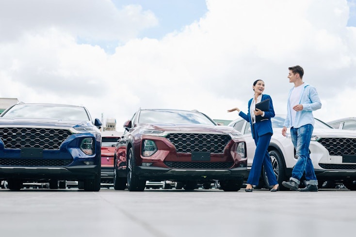 Image of a man walking past cars