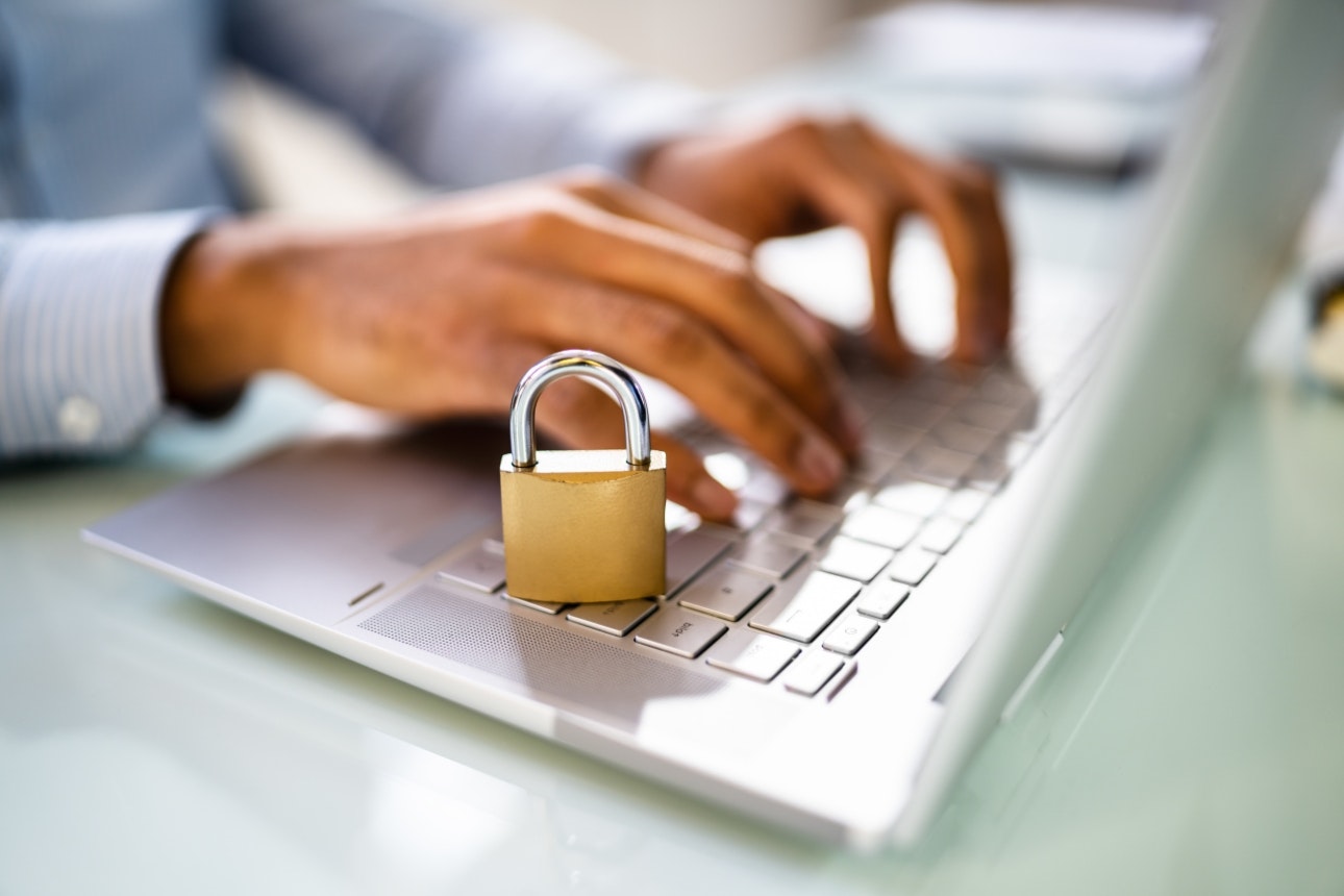 Image of a woman typing on a keyboard with a padlock next to it