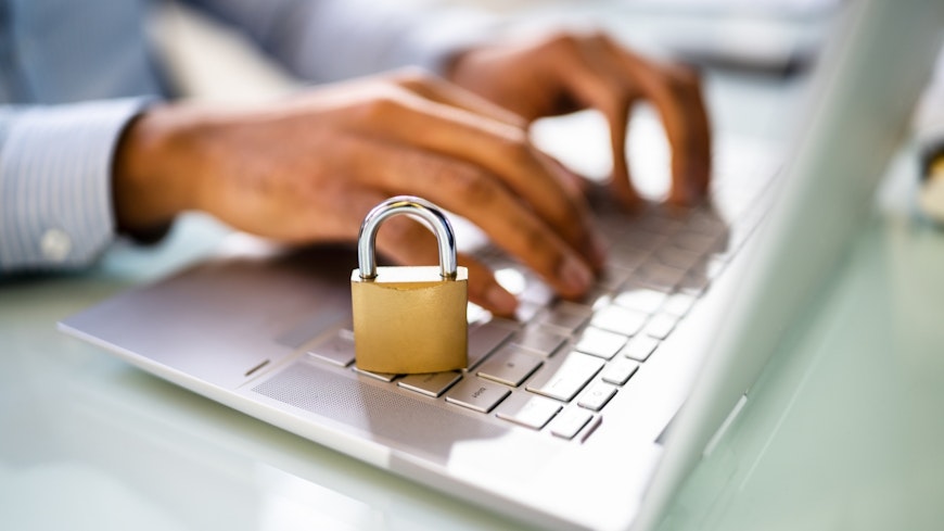 Image of a woman typing on a keyboard with a padlock next to it