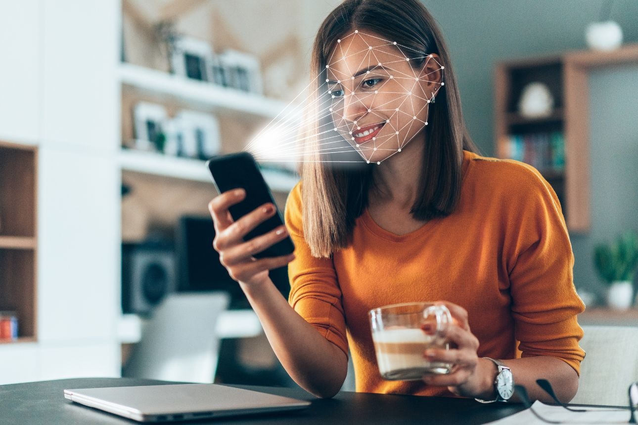 Image of a woman using facial ID to unlock phone