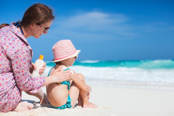 Image of a mother applying sunscreen on daughter