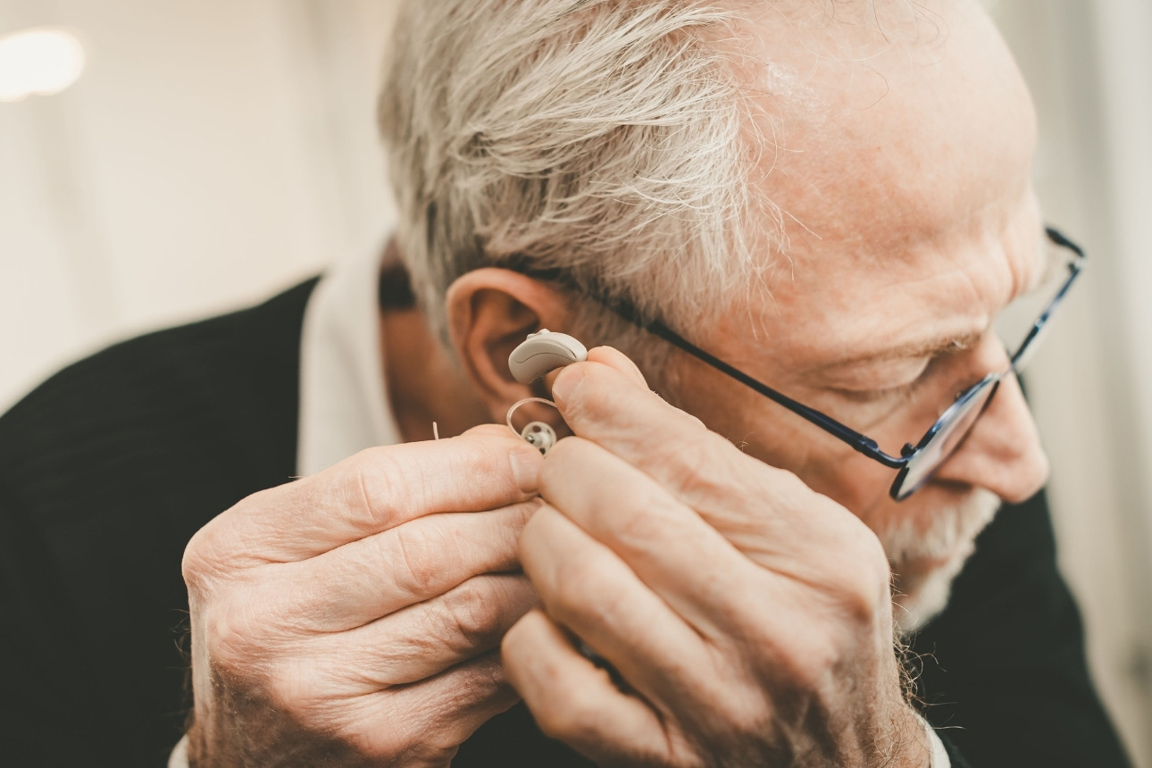 Man putting on hearing aids