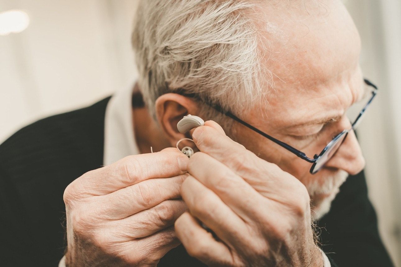 Man putting on hearing aids
