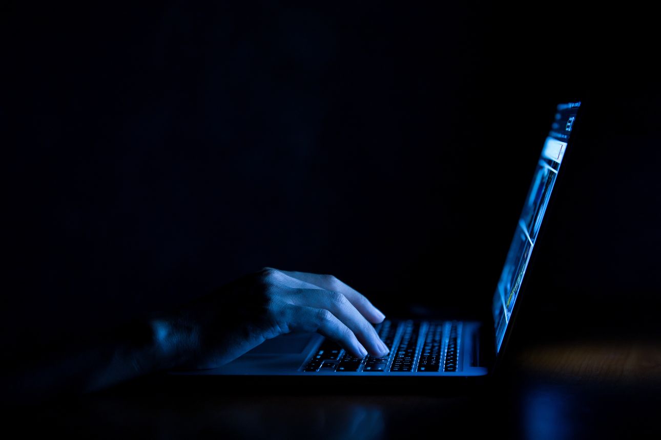 Hacker on laptop in the dark