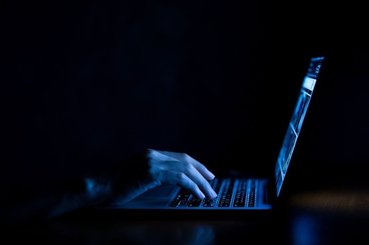 Hacker on laptop in the dark