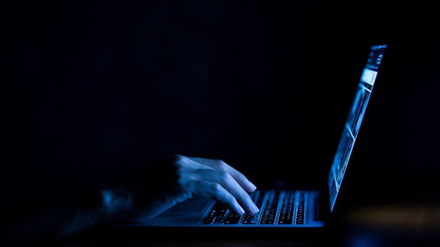 Hacker on laptop in the dark