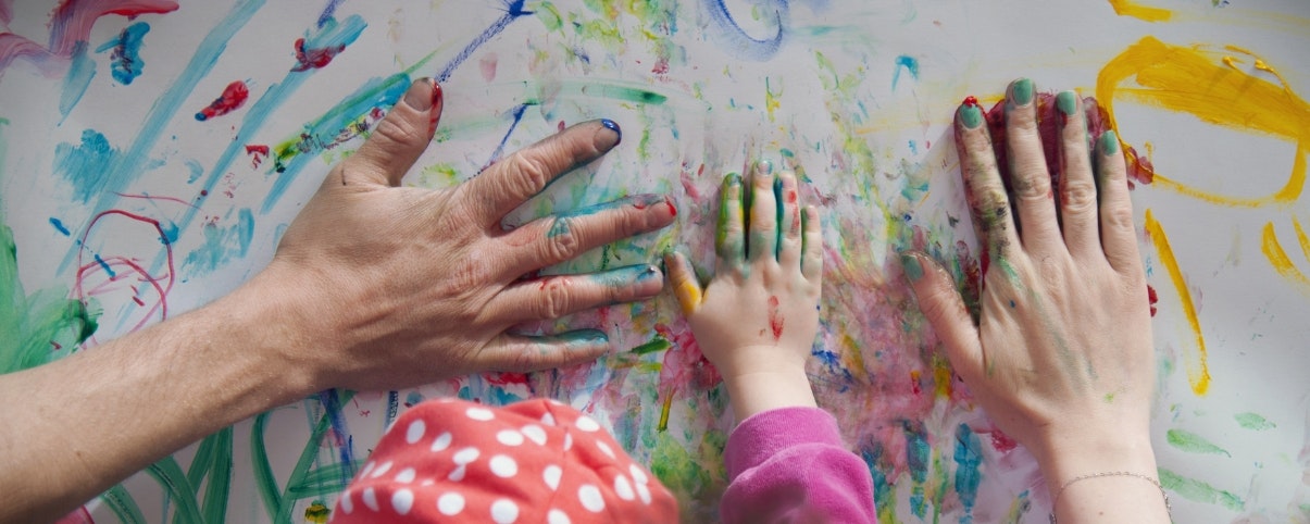 Family painting wall with hands.
