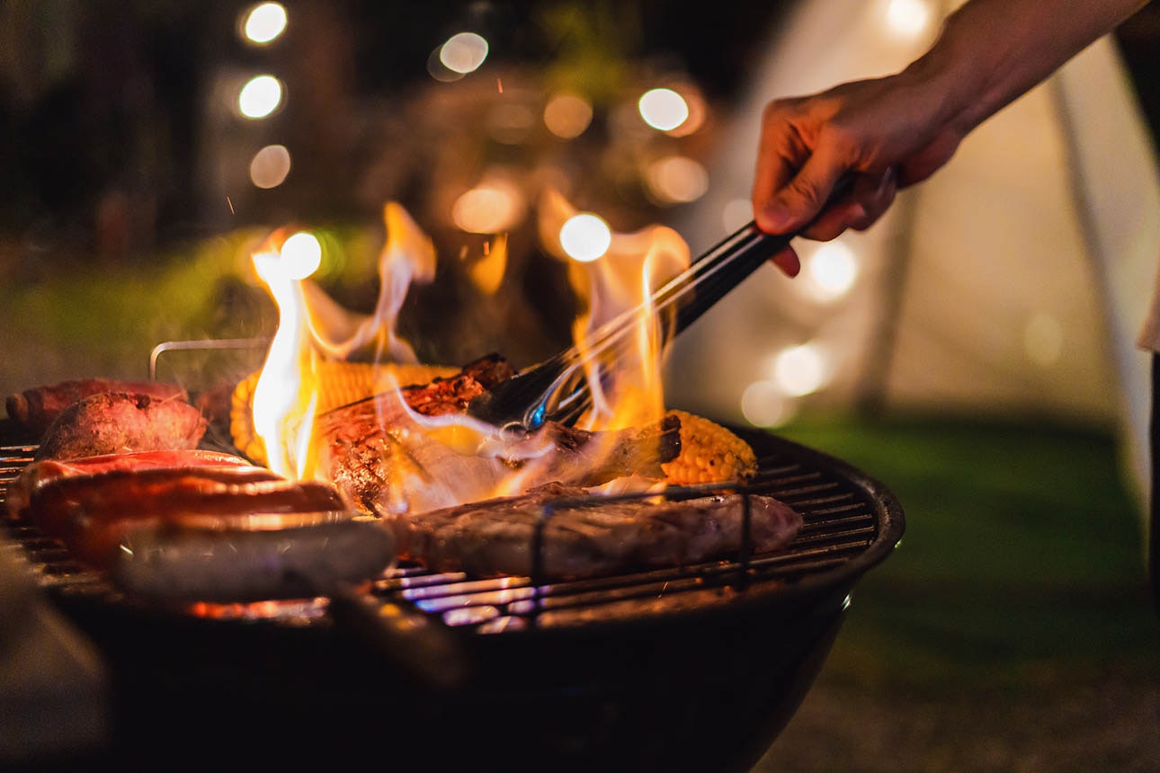 Person barbecuing outdoors at night
