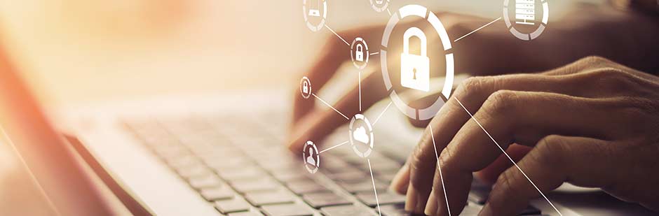 Hands typing on a laptop protected by security software