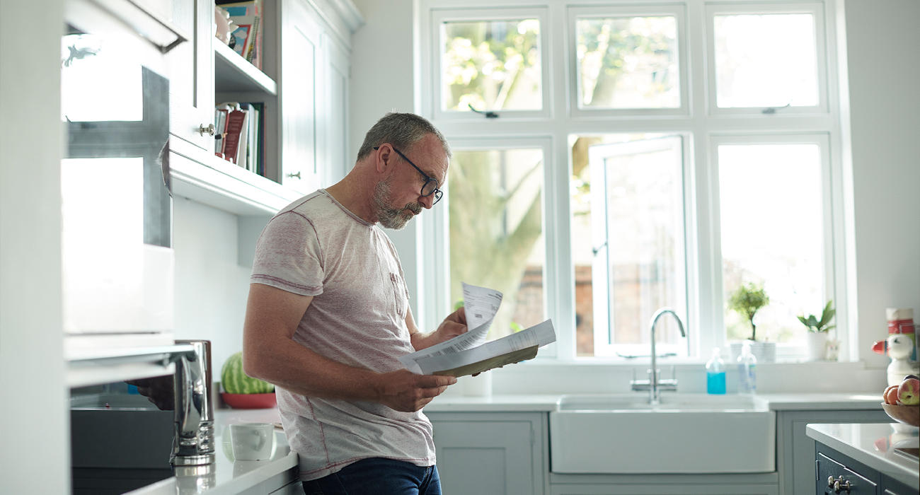 Man inspecting paperwork in the kitchen.