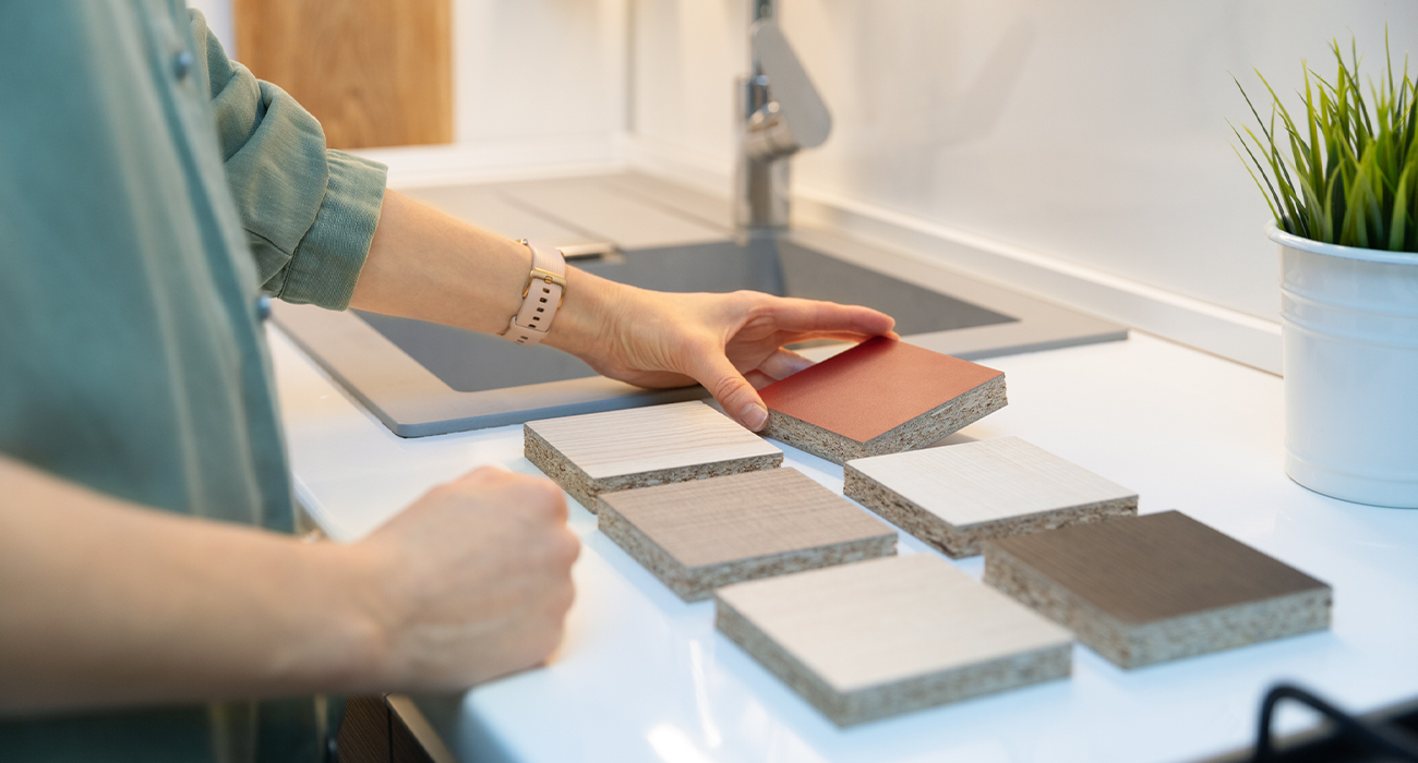 Woman checking kitchen counter surface samples.