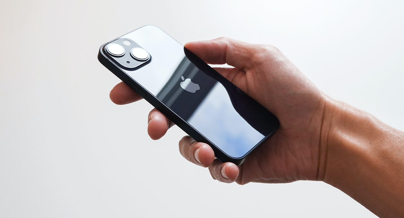 Photograph of person holding iPhone 13 mini.