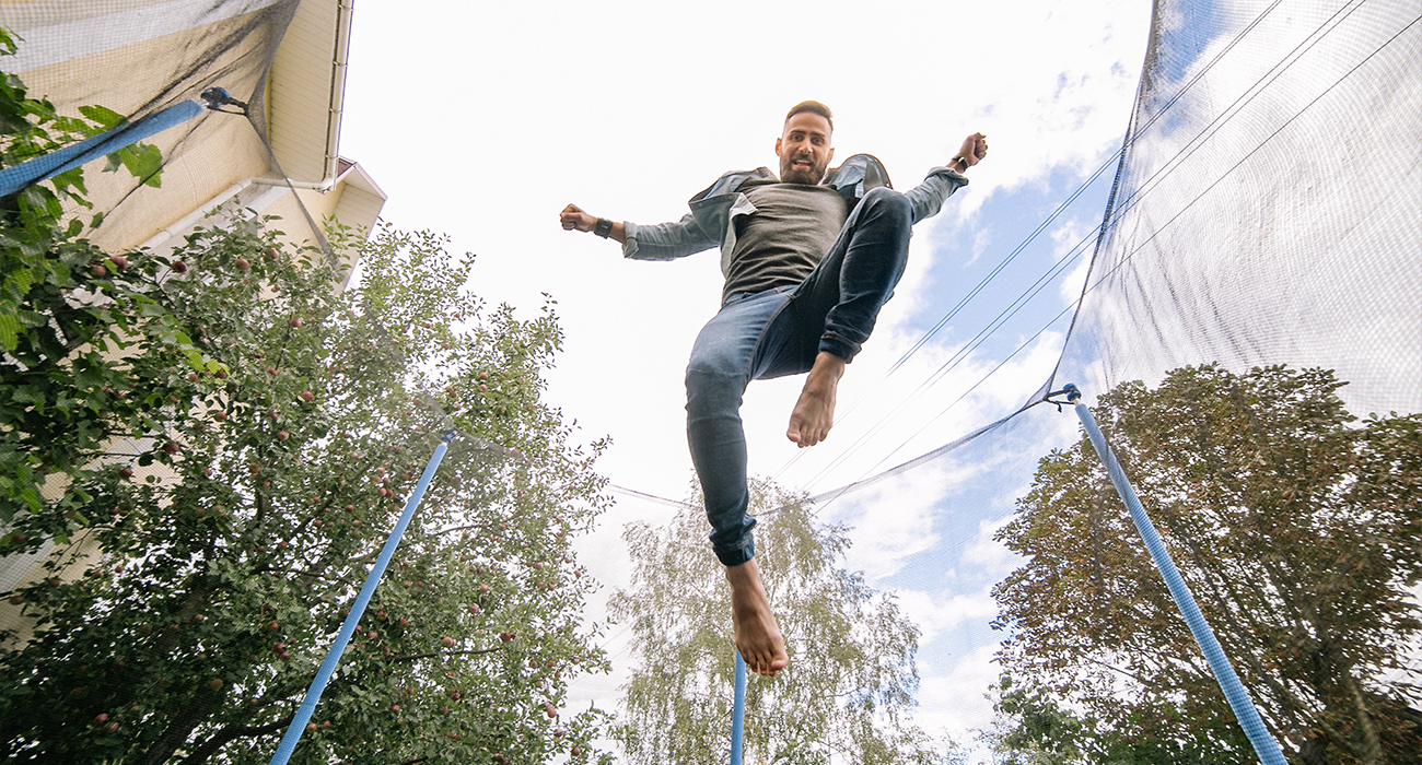Person jumping on outdoor trampoline.