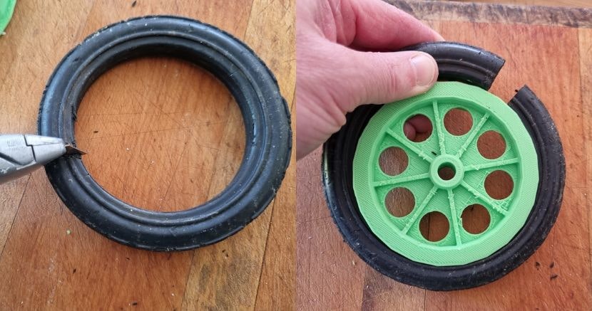 Image of hand attaching tyre on green, 3D-printed Suzy trundler wheel